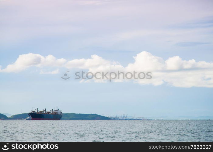 cargo ship Moored at sea. Behind the mountains. In the morning.