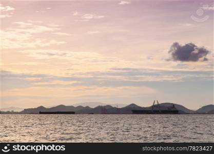 cargo ship Moored at sea. Behind the mountains. In the morning.