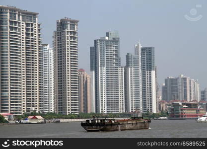 Cargo ship on the river Huangpu and new buildings in Shanghai, China