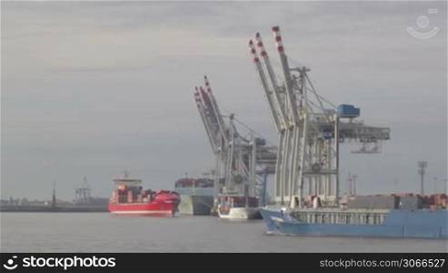 Cargo ship with containers sails across at the Hamburg port.