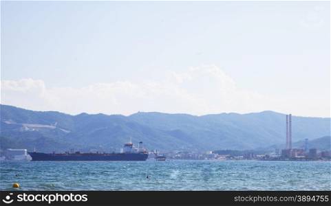 Cargo ship with port in the background, horizontal image