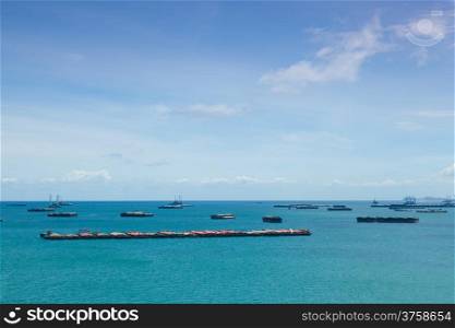 Cargo ships. Moored offshore. In the daytime sky with little clouds.