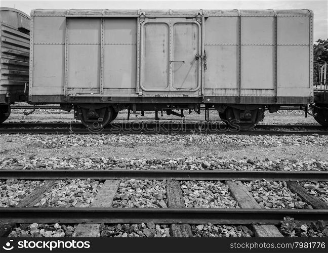 Cargo train and wooden rails track in black and white image
