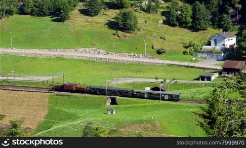 Cargo train on the railway in mountain valley in Switzerland