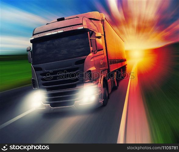 Cargo truck speeding on highway at sundown