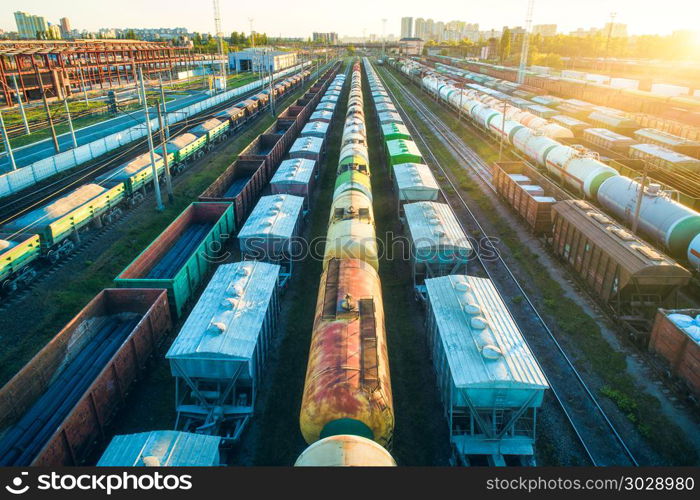 Cargo wagons. Aerial view of colorful freight trains. Railway station. Colorful wagons with goods on railroad. Heavy industry. Industrial landscape with train, railway platfform at sunset. Top view. Aerial view of colorful freight trains on railroad