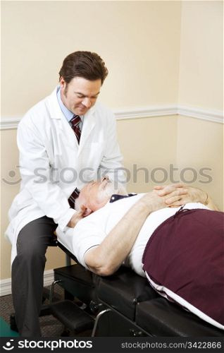 Caring chiropractor gently adjusts a senior man&rsquo;s neck.
