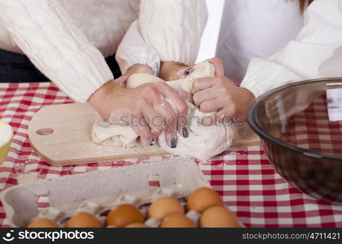 Caring Hands mother helping her daughter prepare dough