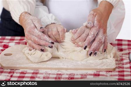 Caring Hands mother helping her daughter prepare dough