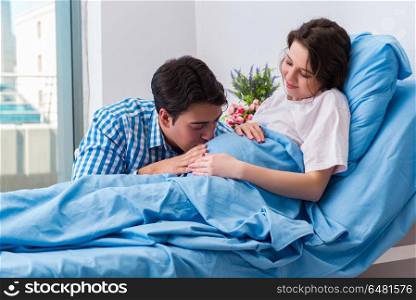 Caring loving husband visiting pregnant wife in hospital