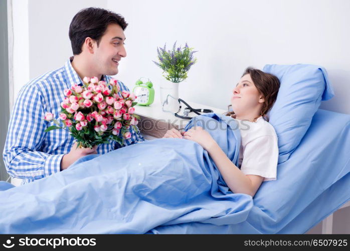 Caring loving husband visiting pregnant wife in hospital