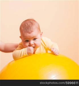 Caring mother doing sport exercises with her baby on fitball. The Baby exercises