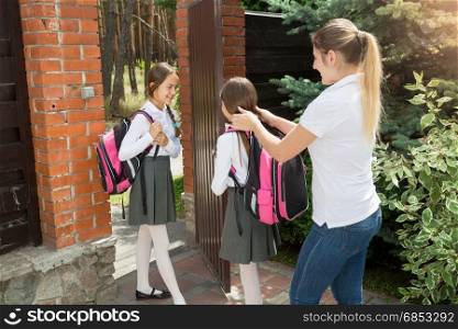 Caring mother seeing off her daughters to school