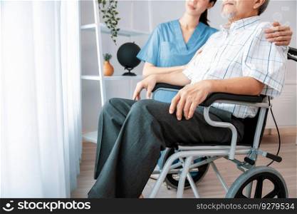 Caring nurse and a contented senior man in a wheel chair at home, nursing house. Medical for elderly patient, home care for pensioners.. Caring nurse and a contented senior man in a wheel chair at home.