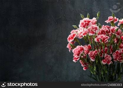 Carnation flowers bouquet. Dark moody background with copy-space.