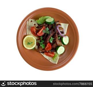 Carnitas - dish of Mexican cuisine.with pork, tomatoes and vegetables