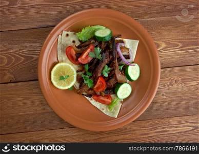 Carnitas - dish of Mexican cuisine.with pork, tomatoes and vegetables