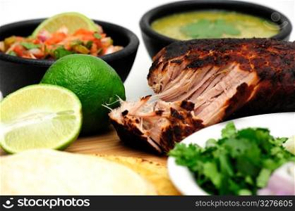 Carnitas. Pork roast cooked to make Mexican carnitas with fresh tortilla&rsquo;s&rsquo; chunky tomato salsa and salsa verde and sliced limes