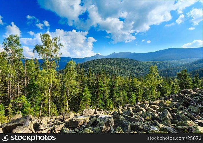 Carpathian Mountain (Ukraine) summer landscape with sky and cumulus clouds, fir forest and slide-rocks.
