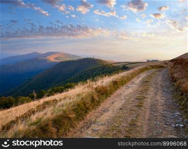 Carpathian Mountains (Ukraine) autumn landscape with cattle-breeding farm and country road.