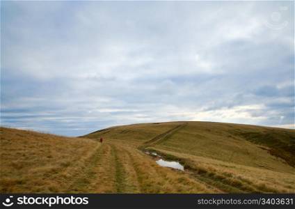 Carpathian Mountains (Ukraine) autumn landscape with country road and photographer
