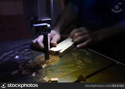 Carpenter builder working with electric jigsaw and wood. Woodworker cutting a piece of wood
