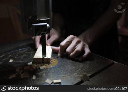 Carpenter builder working with electric jigsaw and wood. Woodworker cutting a piece of wood