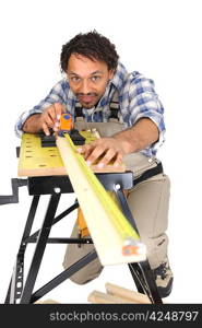 Carpenter carefully measuring plank of wood