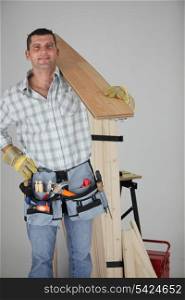 Carpenter carrying a wooden plank