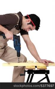 Carpenter drilling a piece of wood