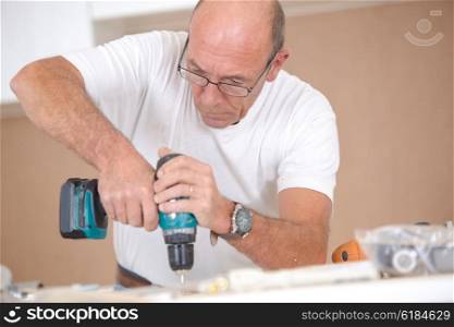 Carpenter drilling into a wooden surface