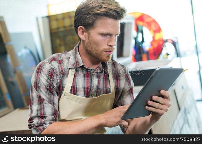 carpenter entrepreneur holding a tablet in the workshop