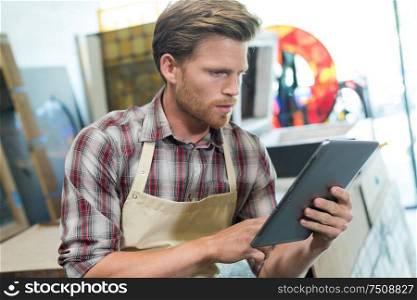 carpenter entrepreneur holding a tablet in the workshop
