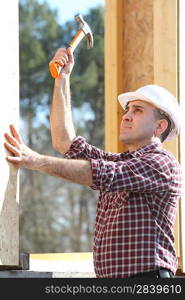 Carpenter erecting wooden house