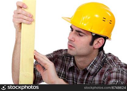 Carpenter examining plank