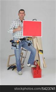 Carpenter holding a blank red sign