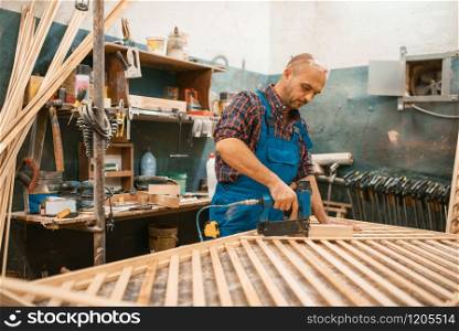 Carpenter in uniform, woodworking, lumber industry, carpentry. Wood processing on furniture factory, production of products of natural materials