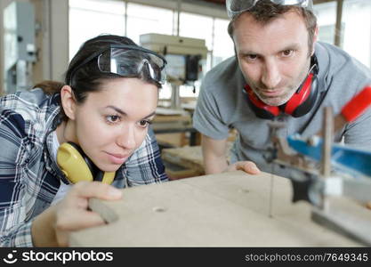 carpenter man and woman in workshop as a team