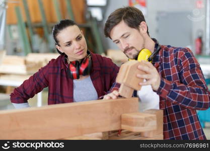 carpenter man and woman working in workshop as a team