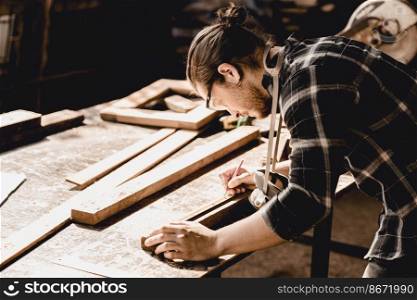 Carpenter man making masterpiece woodworks handcraft furniture in wood workshop.