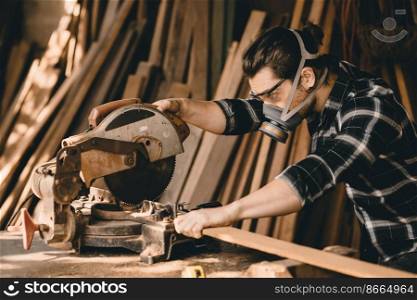 Carpenter man using Electric Wood Cutter machine with protection safety equipments in wood workshop