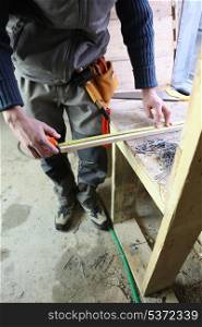 Carpenter measuring plank of wood
