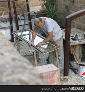 Carpenter preparing window in workshop, Orvieto, Terni Province, Umbria, Italy