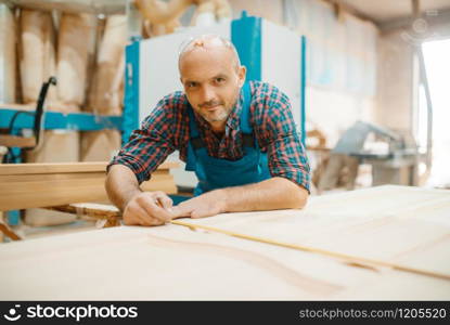 Carpenter processes wooden door, woodworking, lumber industry, carpentry. Wood processing on furniture factory, production of products of natural materials. Carpenter processes wooden door, woodworking