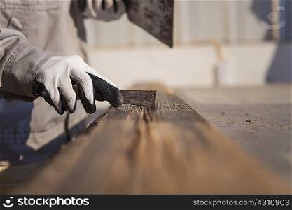 Carpenter scraping wood plank in factory, Jiangsu, China