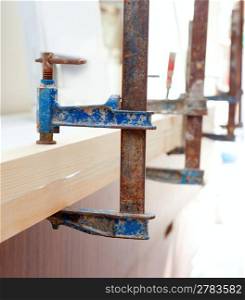 Carpenter screw clamp tools pressing wood slats ang white glue