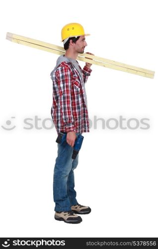 carpenter standing in profile holding ruler over his shoulder