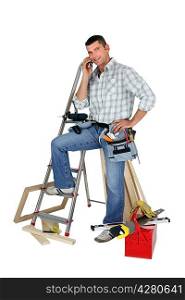 Carpenter stood by equipment making call