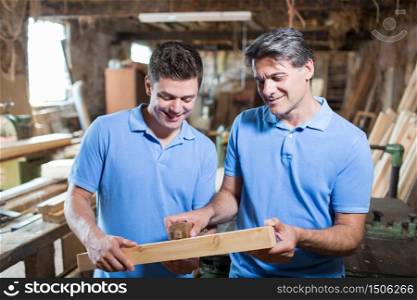 Carpenter Teaching Apprentice How To Measure Wood