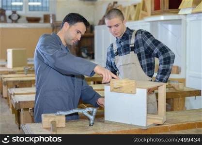 carpenter trainee listening to teacher in workshop